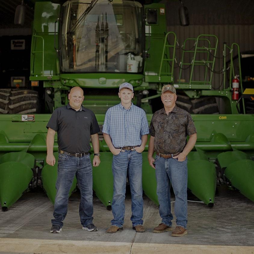 Customers standing by farm corn harvesting equipment leased by agfi with 0% down