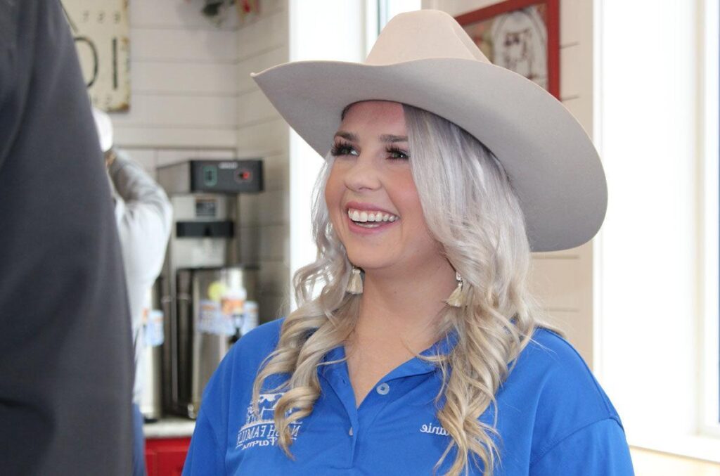 Young woman farmer smiling, representing the beginning farmers supported through FSA loan programs. 