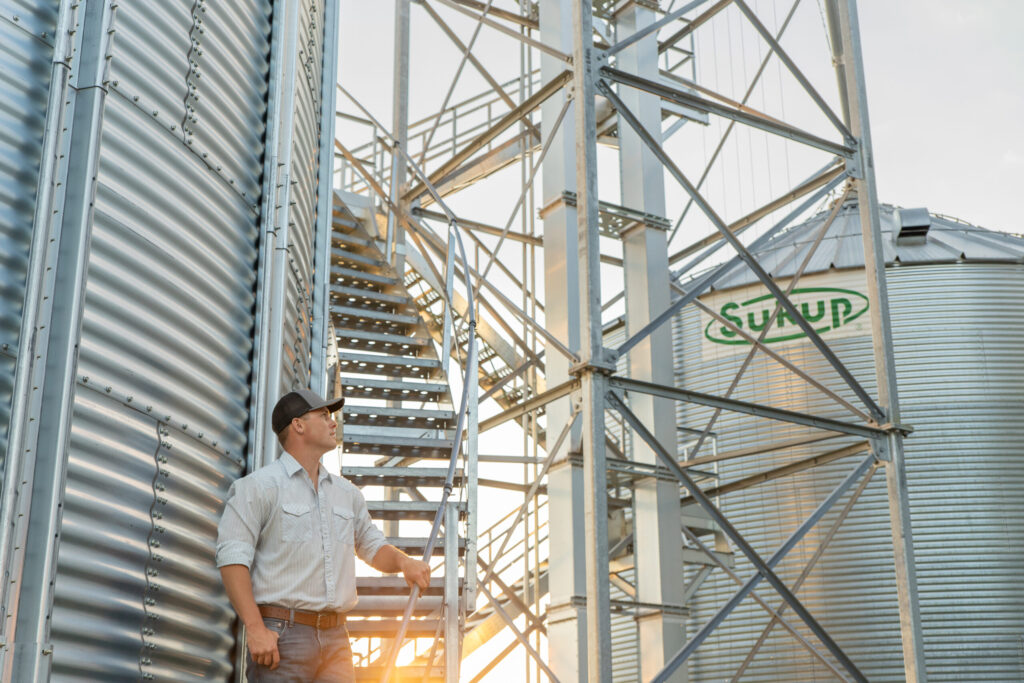 Farmer Working at Grain Operation with Sukup Bins Discussing Financing Project with AgFi Lease